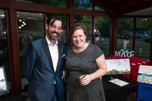 A lady takes a picture with her best magician Adam Stone