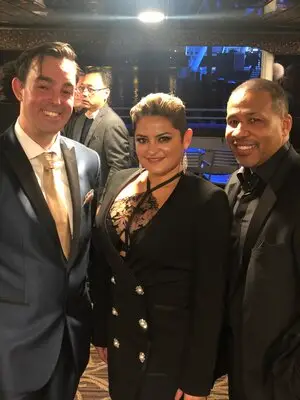 Two fans take a photo with magician Adam Stone